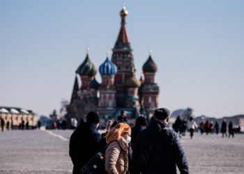 A woman wearing a protective face mask due to fears of the coronavirus disease (COVID-19) walks on Red Square in front of St.Basil's Cathedral in downtown Moscow on March 17, 2020. (Photo by Dimitar DILKOFF / AFP)