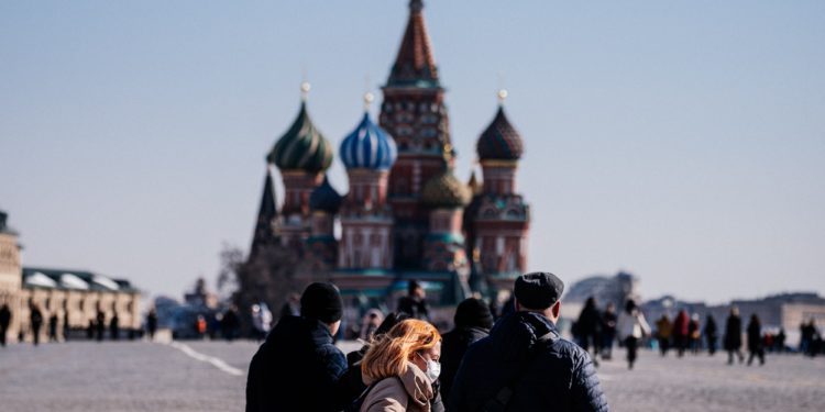 A woman wearing a protective face mask due to fears of the coronavirus disease (COVID-19) walks on Red Square in front of St.Basil's Cathedral in downtown Moscow on March 17, 2020. (Photo by Dimitar DILKOFF / AFP)