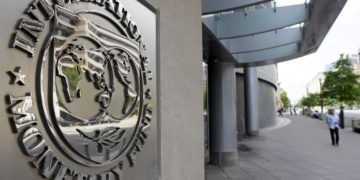 Pedestrians walk past the International Monetary Fund headquarters' complex in Washington Sunday, May 2, 2010. A senior International Monetary Fund official says the IMF's executive board is meeting in Washington to consider how much aid to grant Athens under a massive rescue loan package. (AP Photo/Cliff Owen)