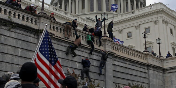 Supporters of U.S. President Donald Trump climb a wall during a protest against the certification of the 2020 presidential election results by the Congress, at the Capitol in Washington, U.S., January 6, 2021. Picture taken January 6, 2021. REUTERS/Jim Urquhart