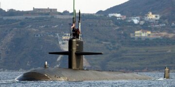 Port bow view showing US Navy (USN) Sailors manning a topside watch aboard the Los Angeles Class Attack Submarine USS NEWPORT NEWS (SSN 750), as the ship departs the harbor at Souda Bay, Crete, Greece following a port visit.